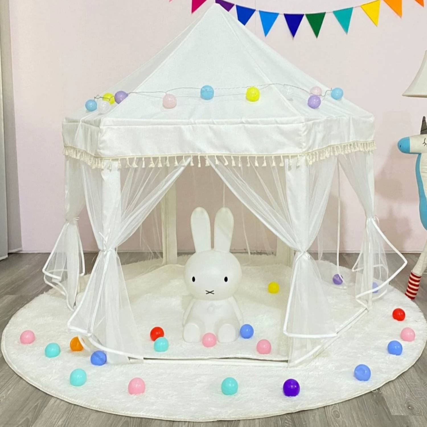 A pink princess castle play tent set up indoors